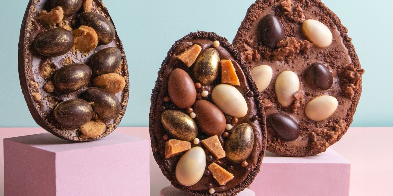 Three Easter eggs halves filled with small eggs and chocolate filling standing upright
